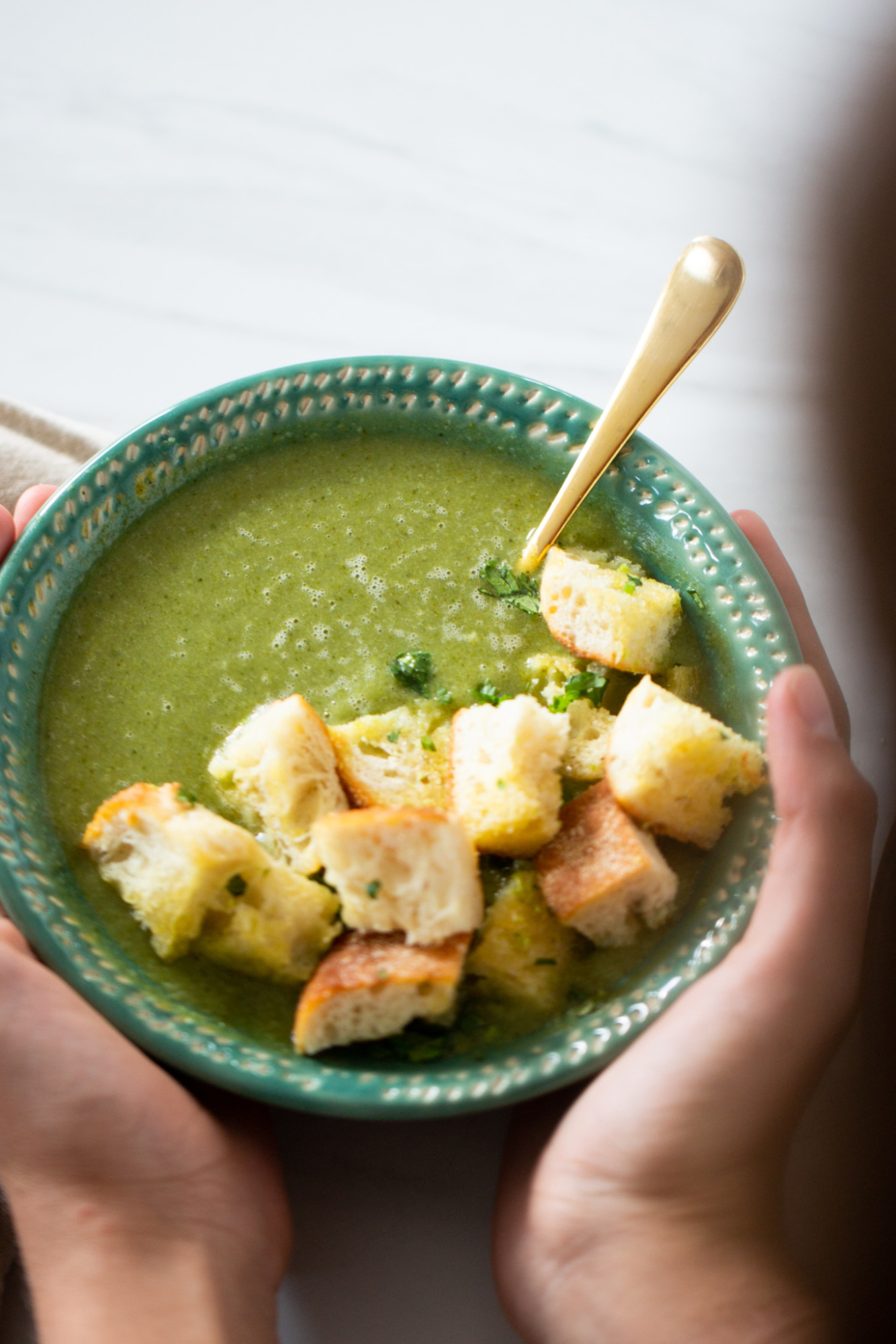 A bowl of broccoli soup with homemade crutons