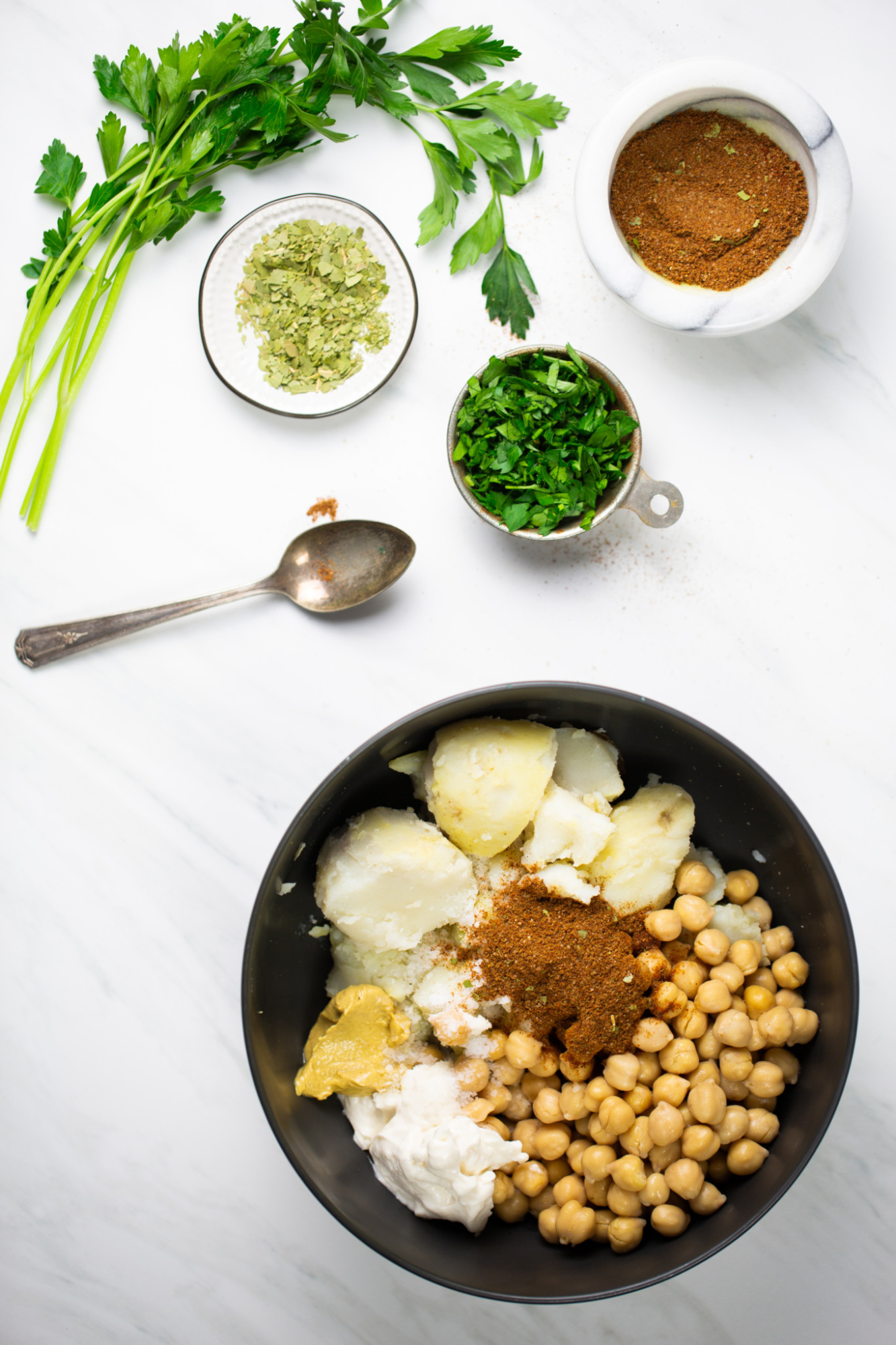 tazón con garbanzos, papas, especias y mayonesa
