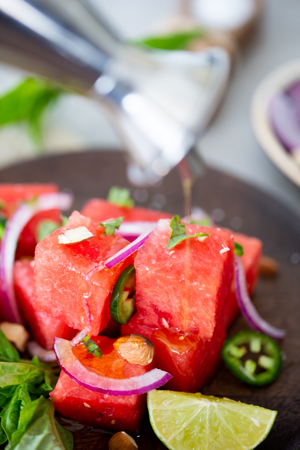 Spicy Watermelon saladbeing drizzled with olive oil .