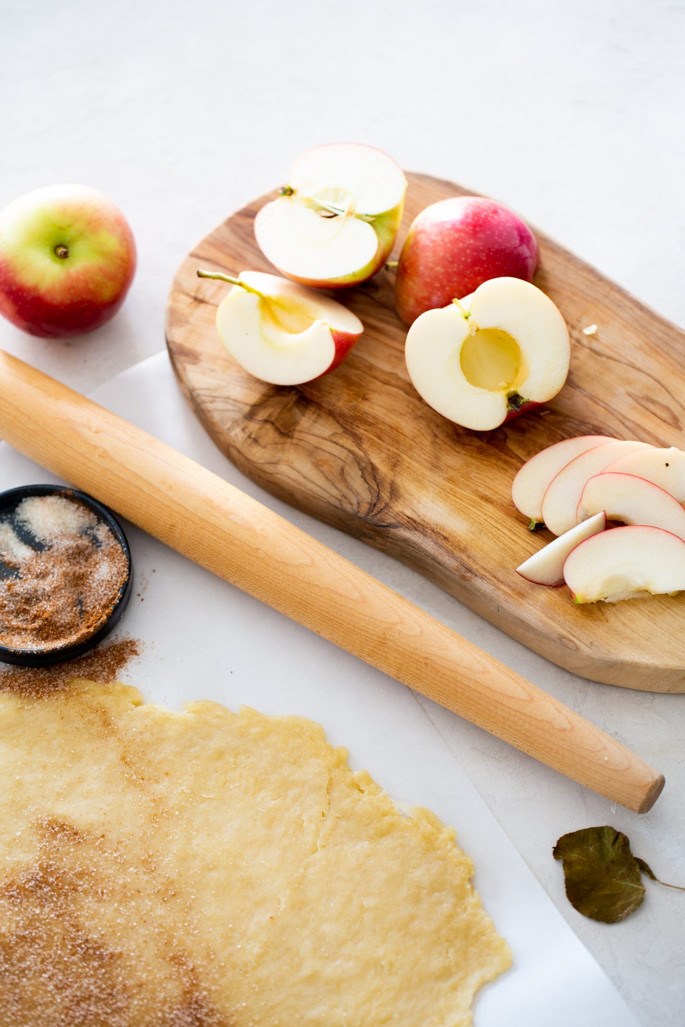 cut apples and rolled dough to prepare the vegan galette