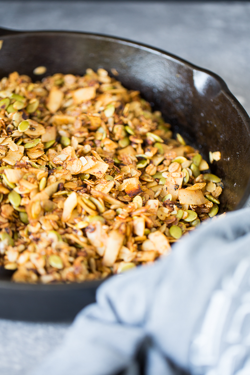 Savory and vegan granola in a glass container.in a cast iron pan