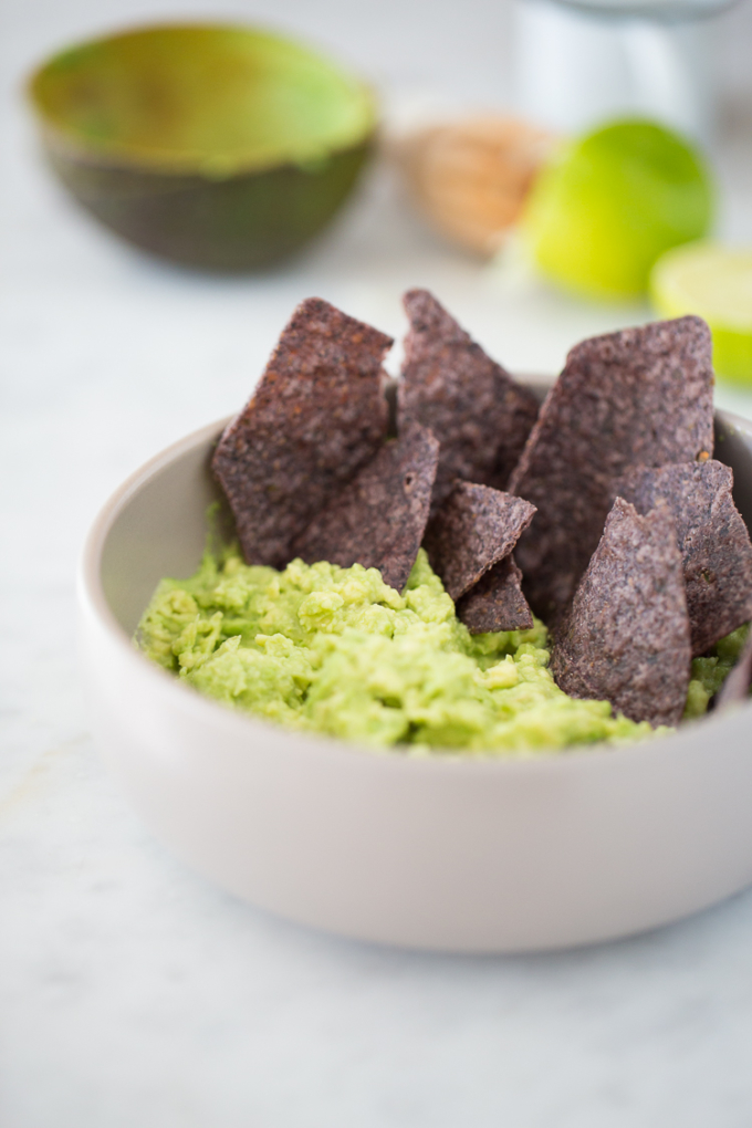 Bowl with a simple guacamole with blue corn masa chips