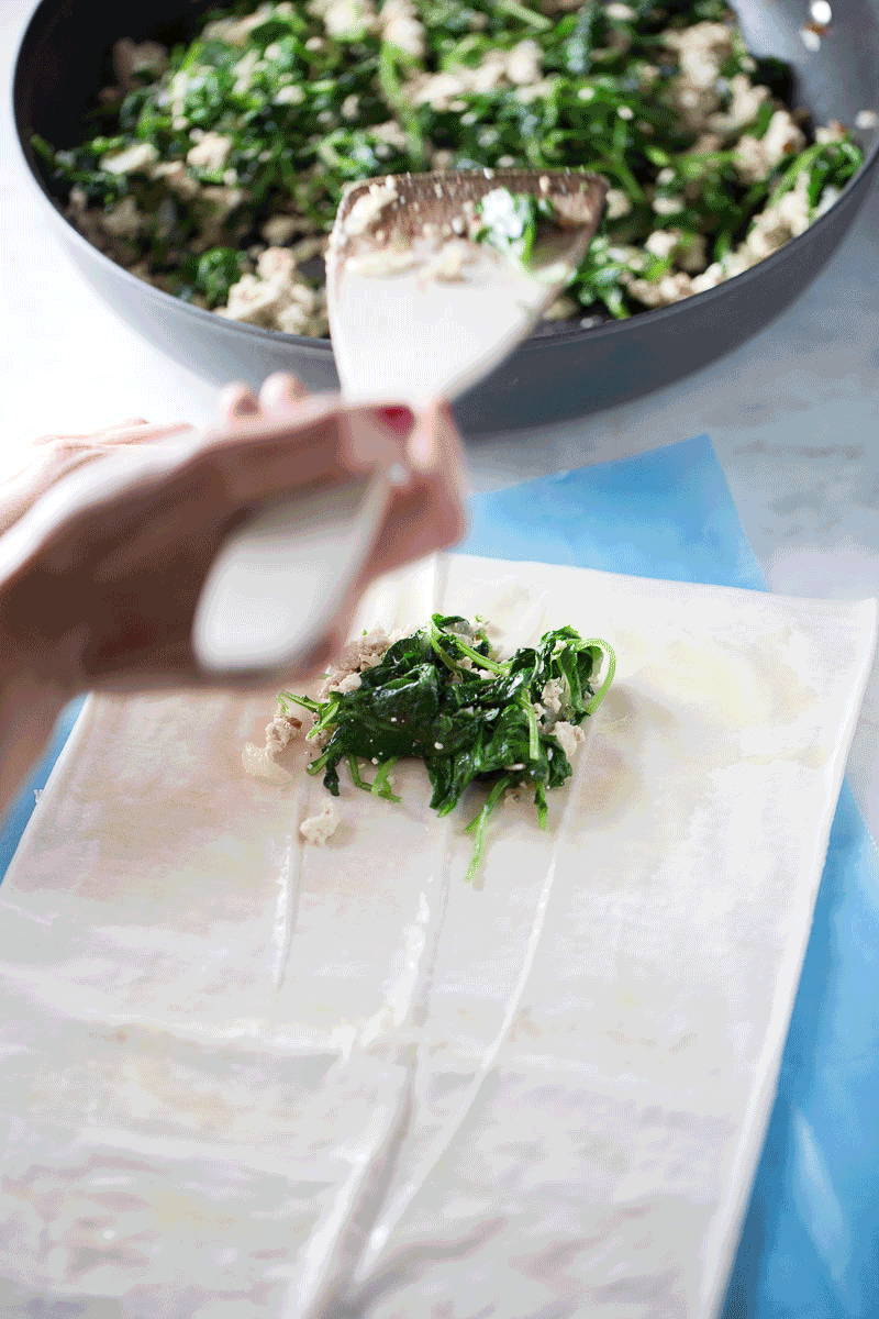 rolling out the fillo dough to make spanakopita