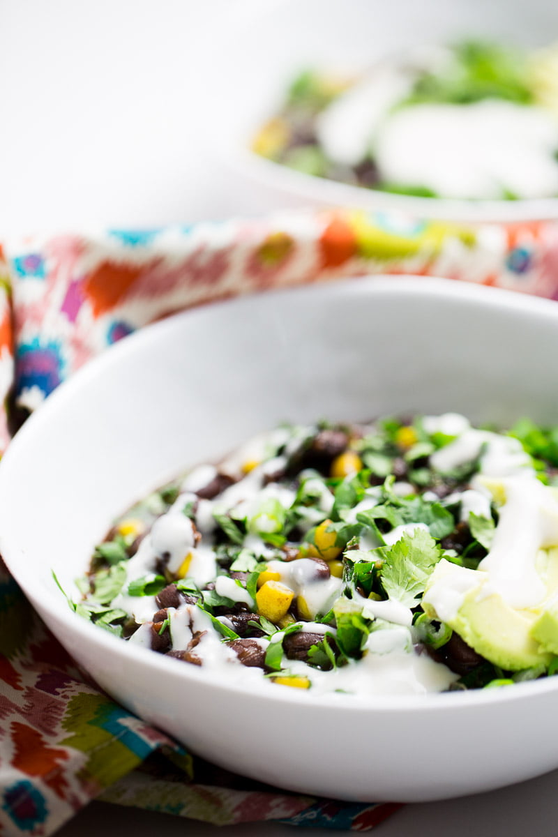 kale and black bean soup topped with  avocado and mexican crema
