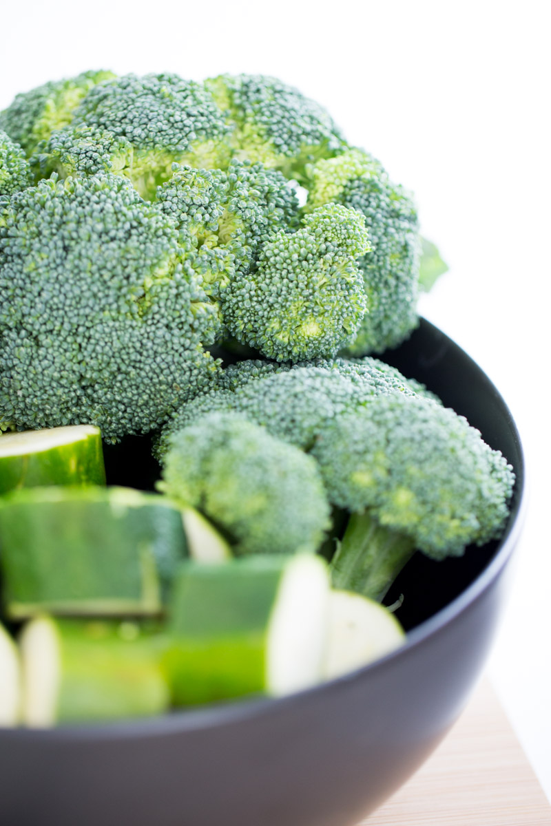 raw BROCCOLI AND ZUCCHINI in a black bowl