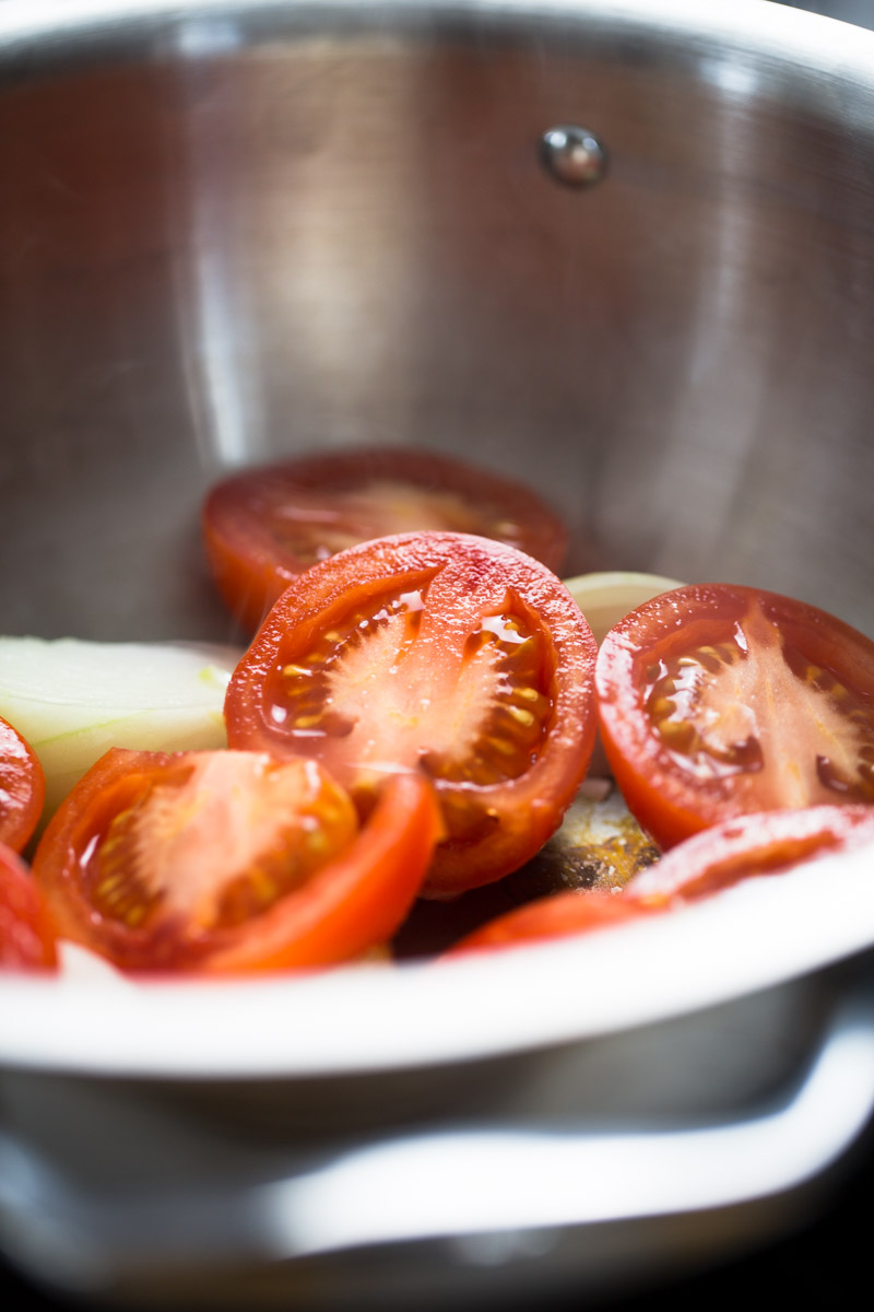 roma tomatoes and onion in a soup pot