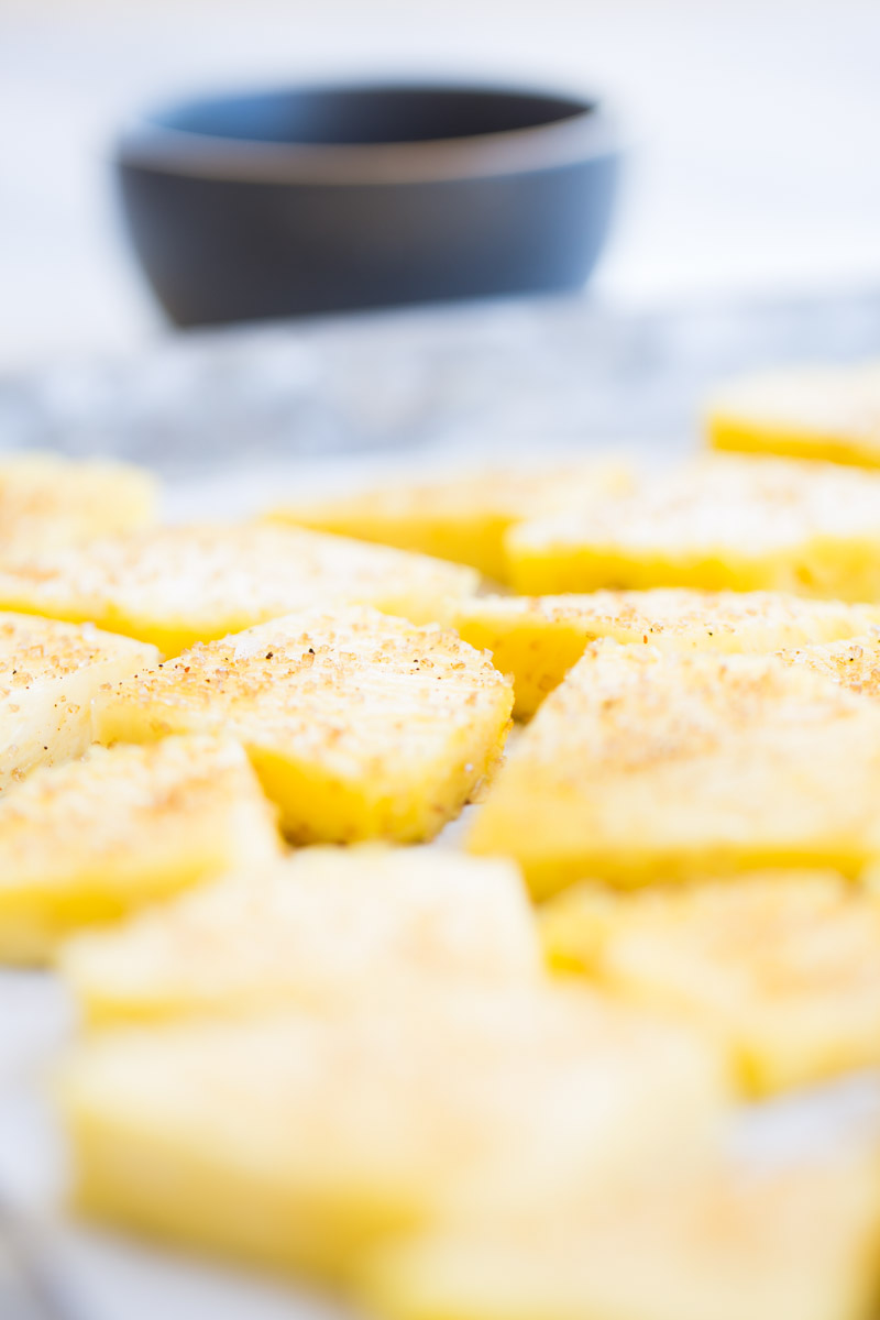 pienapple on a baking sheet sprinkled with brownsugar and chile powder