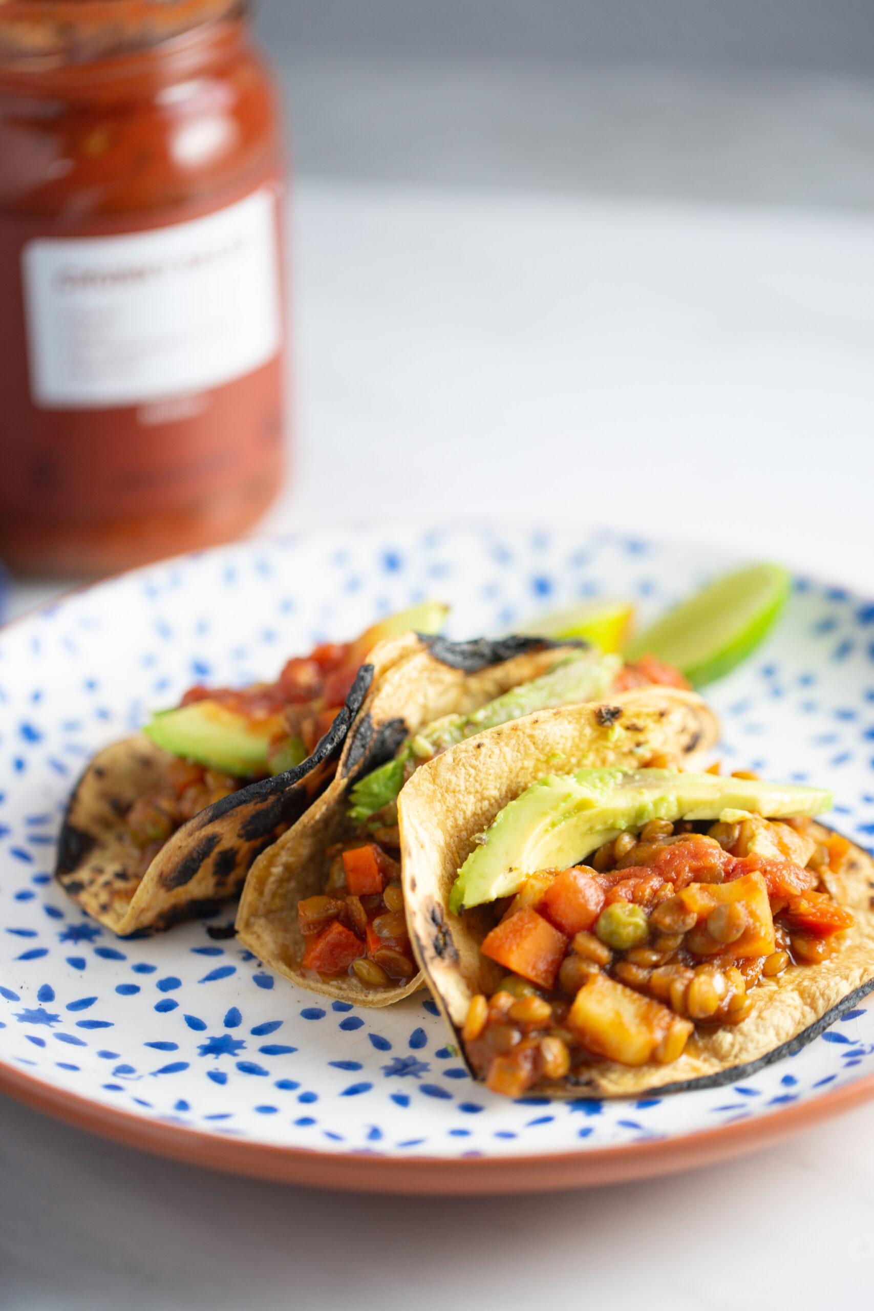 lentil picadillo tacos with corn tortilla and a slice of avocado