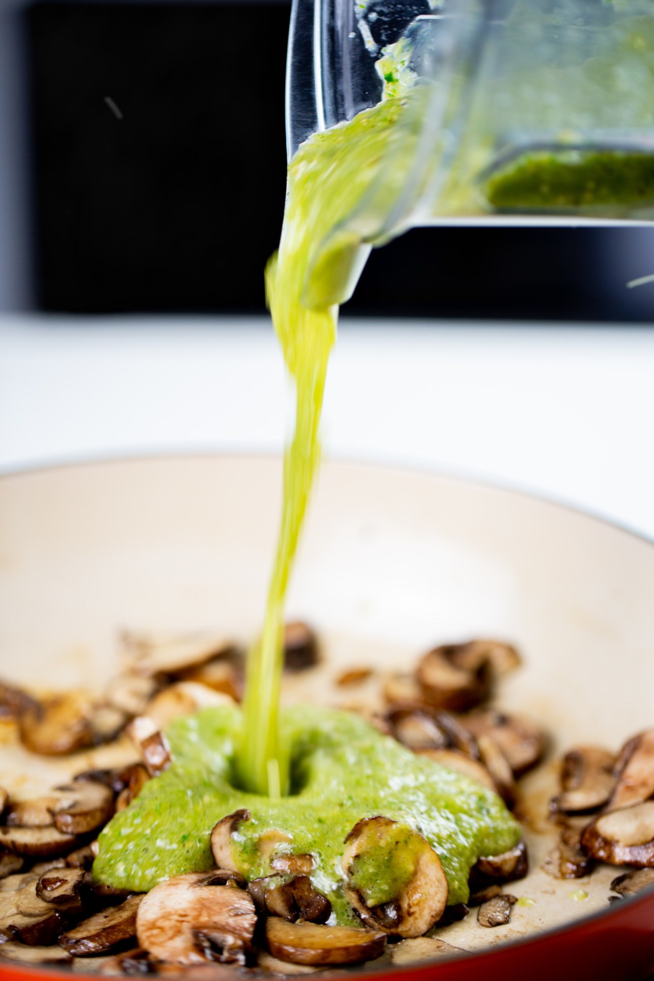 Pouring salsa verde over mushrooms