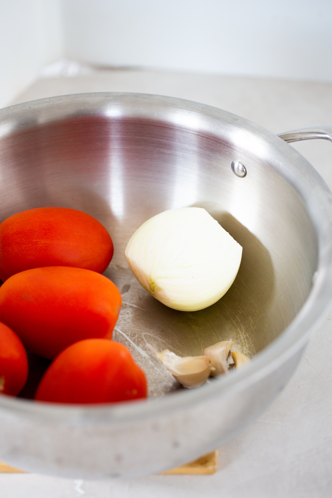 tomato onion and garlic roasting in a soup pot