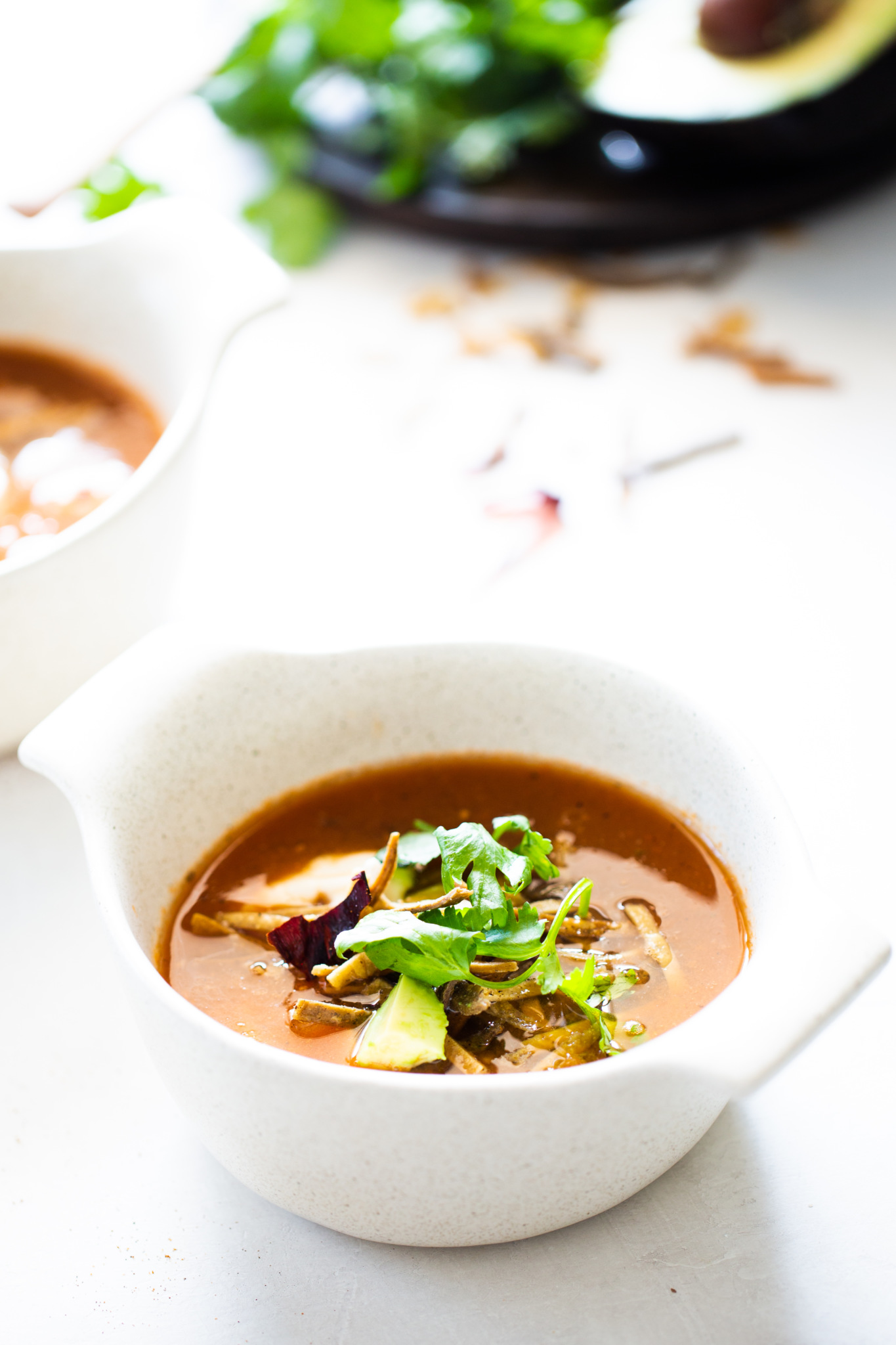 a bowl of vegan tortilla soup (sopa azteca) with cilantro, avocado and chile seco