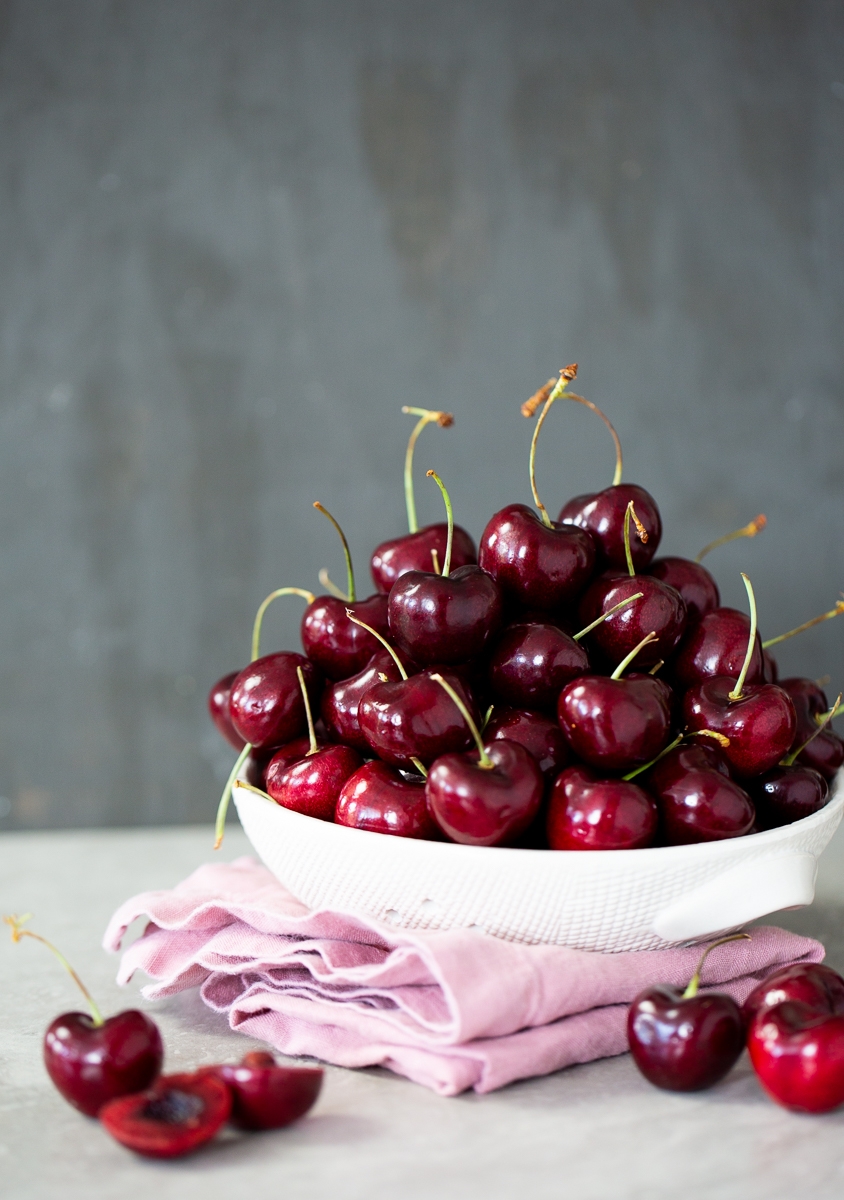 bowl of cheries over a pink piece of cloth