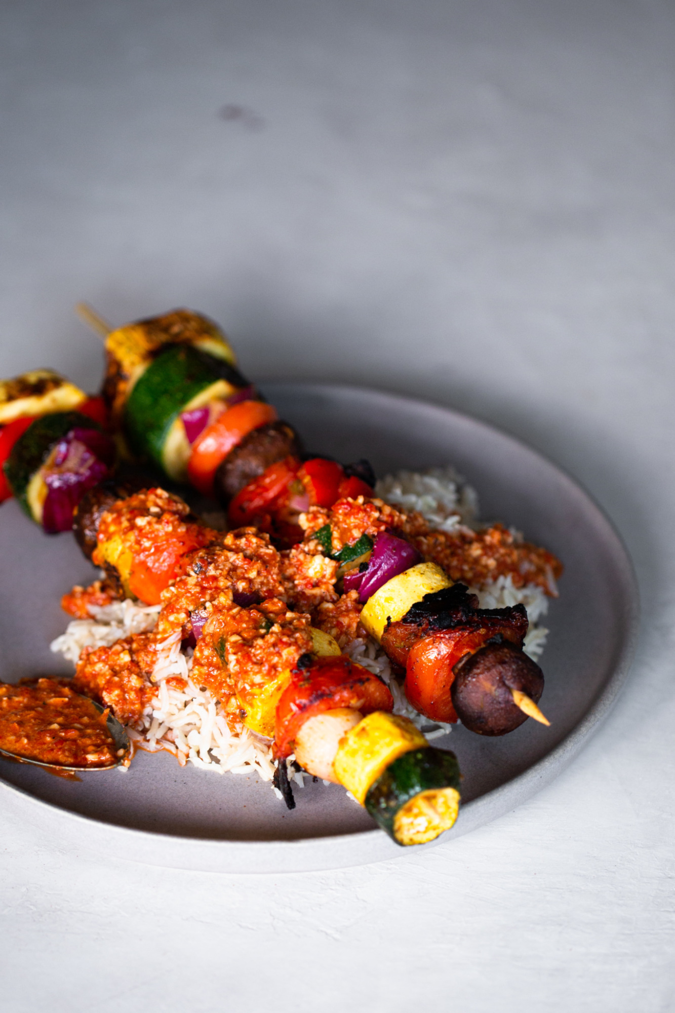 grilled vegetable kebabs over brown rice and drizzled with romesco sauce
