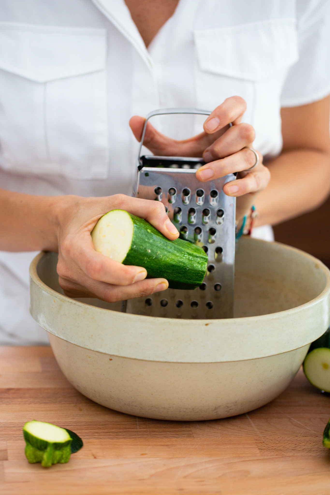 grating zucchini in a clay bowl