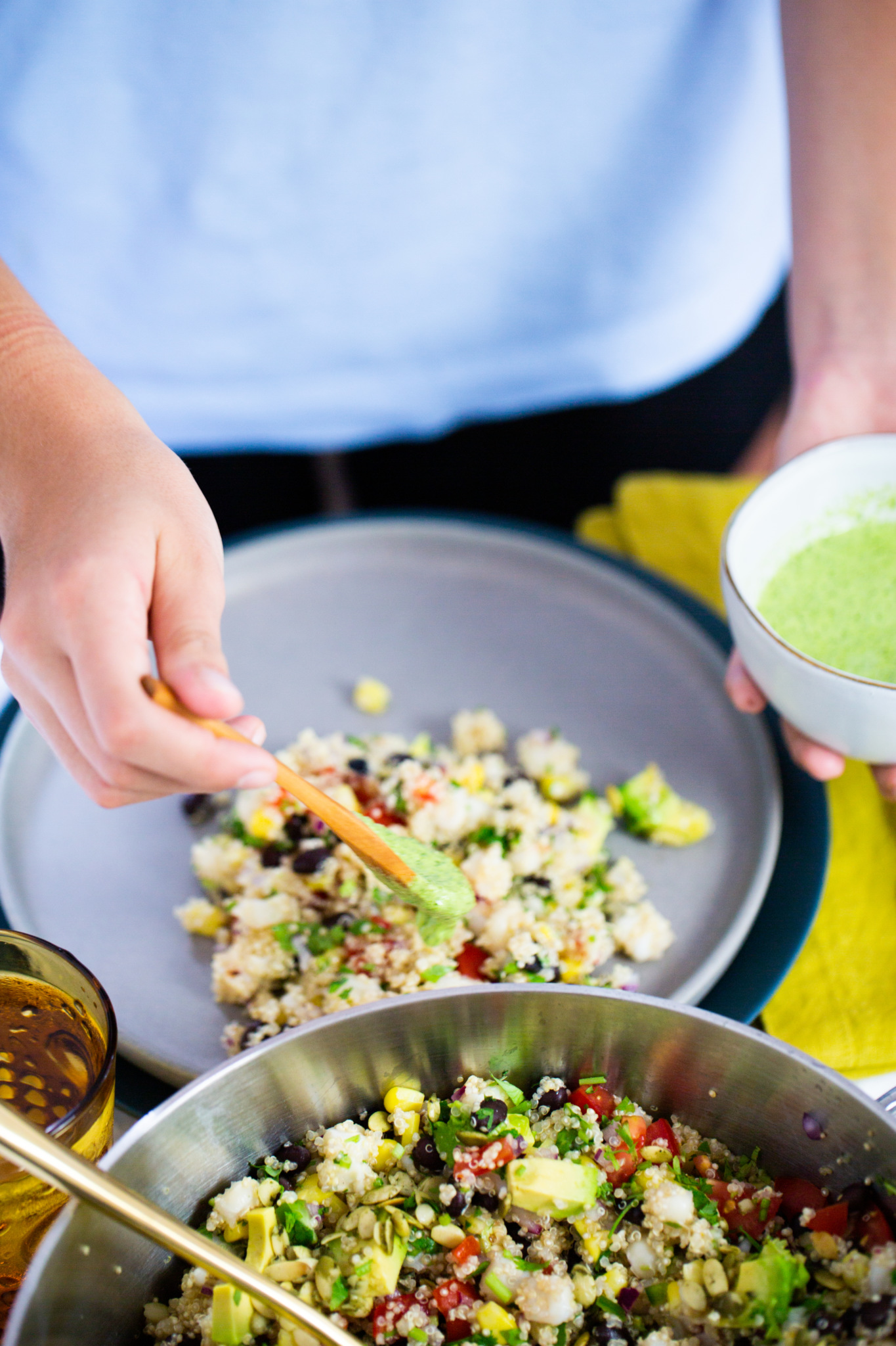 putting cilantro cream on top of Mexican quinoa salad