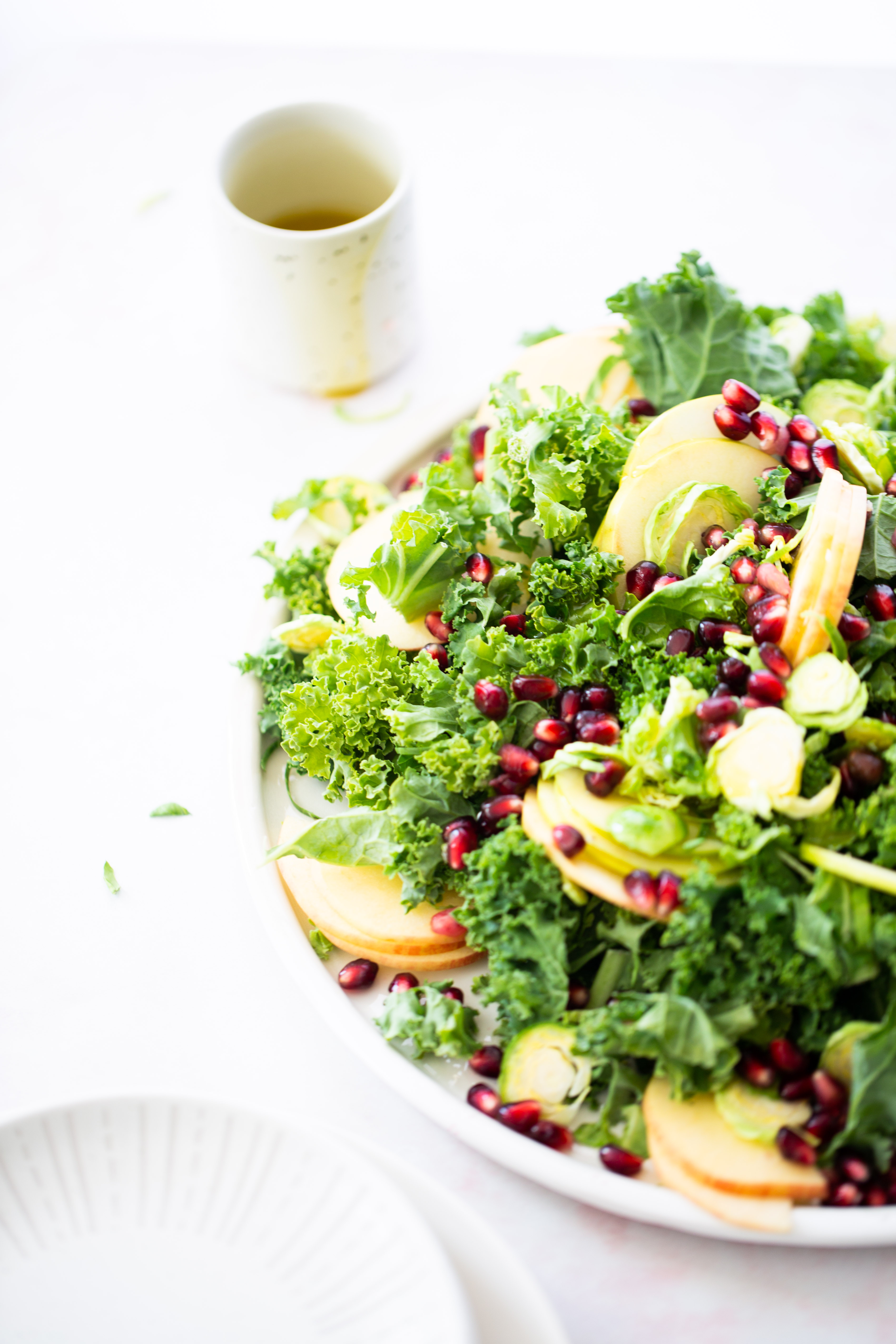 A plate of kale salad with apples and pomegranate, perfect for a healthy meal.