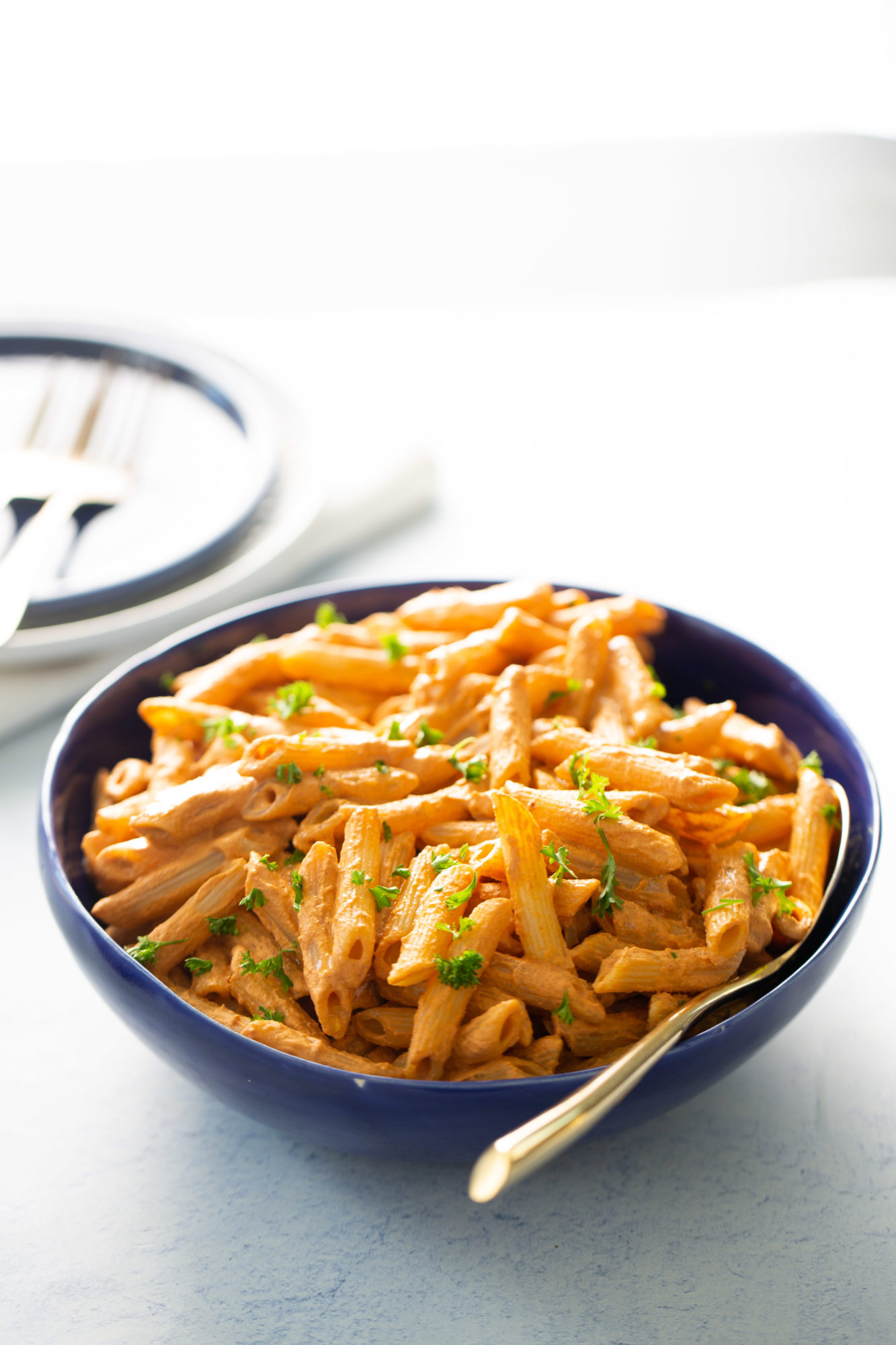 A vegan roasted red pepper pasta dish displayed on a table.