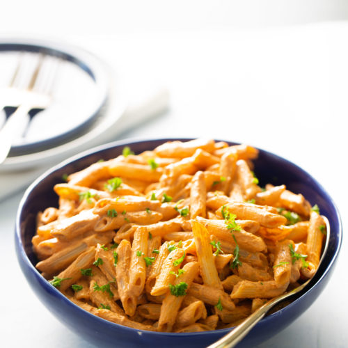 A vegan roasted red pepper pasta dish displayed on a table.