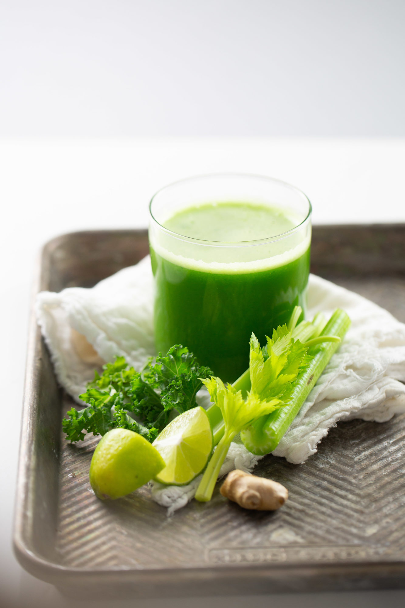 jugo verde con lim&oacute;n y apio a un lado