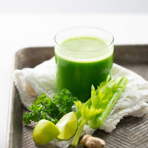 jugo verde con limón y apio a un lado