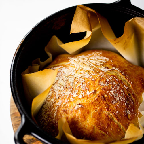 A loaf of bread in a cast iron pan.