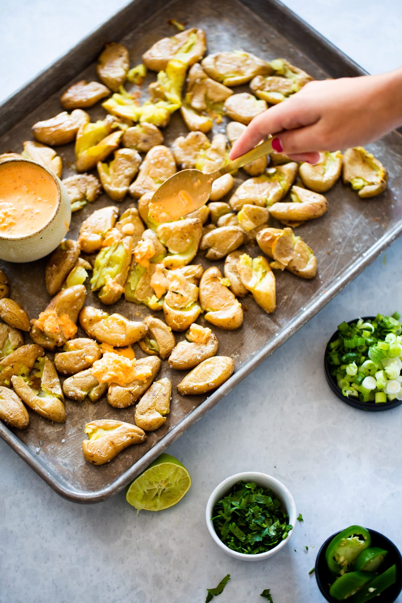 finishing smashed potatoes with kimchi mayo