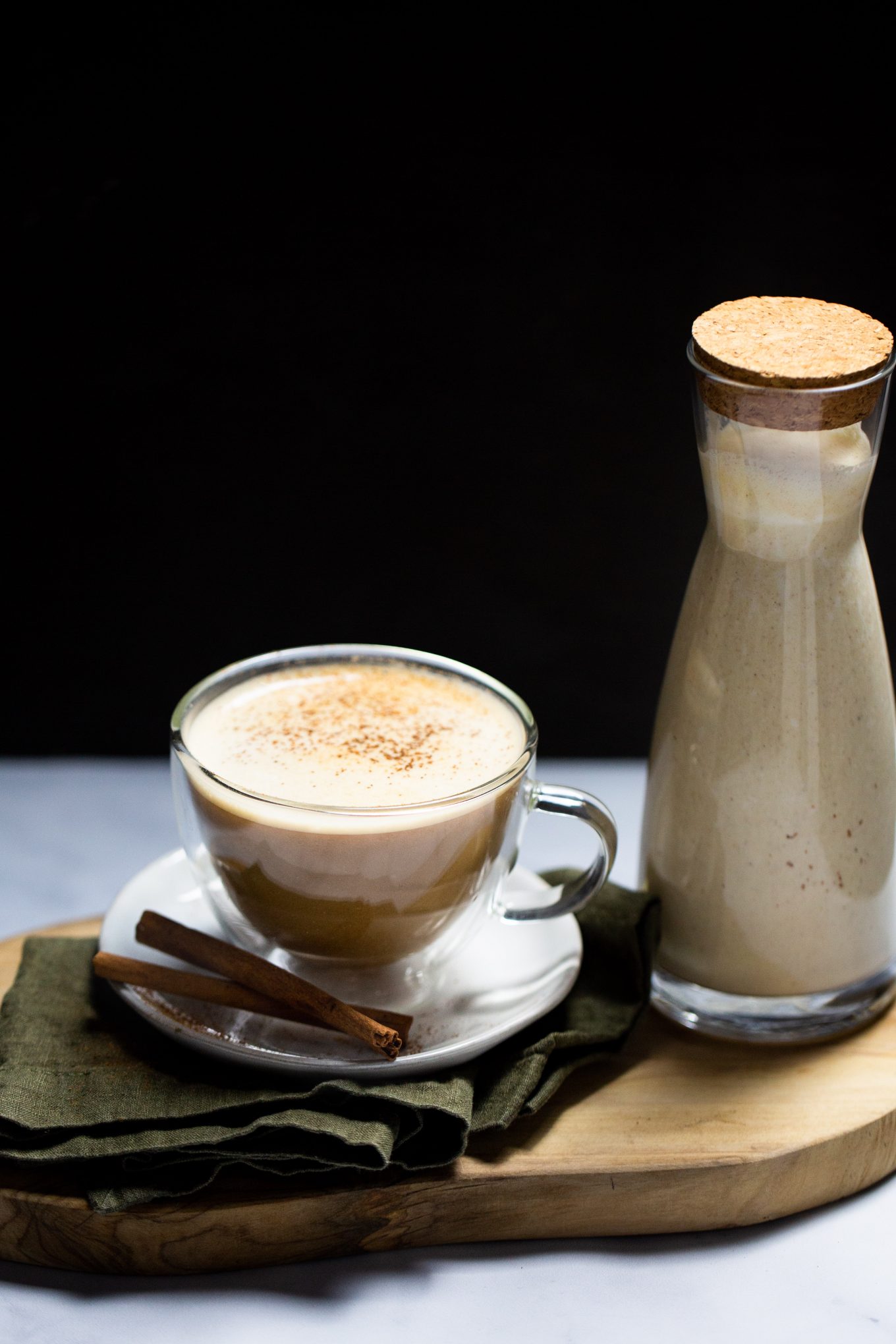 Jar with pumpkin spice creamer and cup of coffee with it.