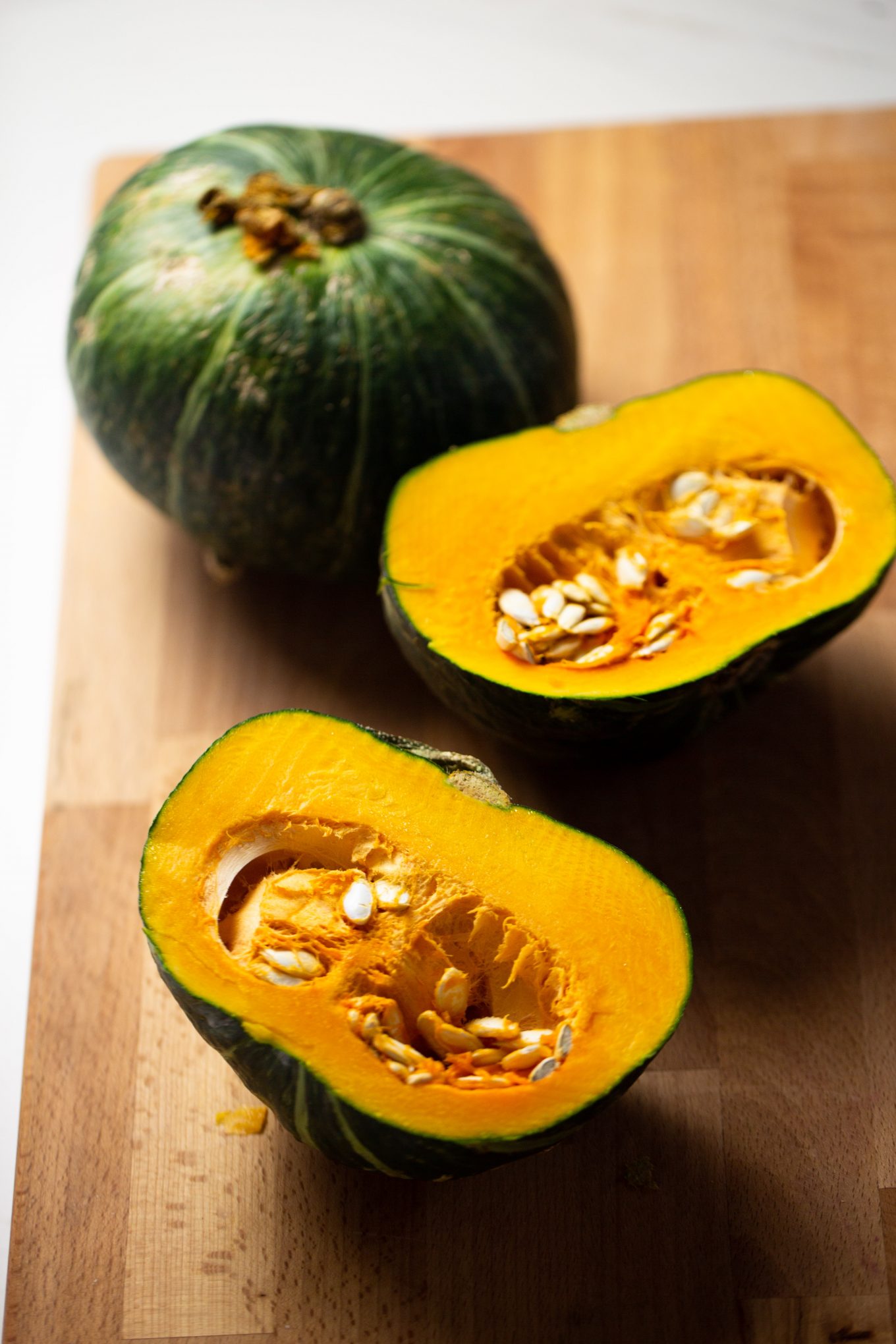 one whole kabocha pumpkin and one cut in half.