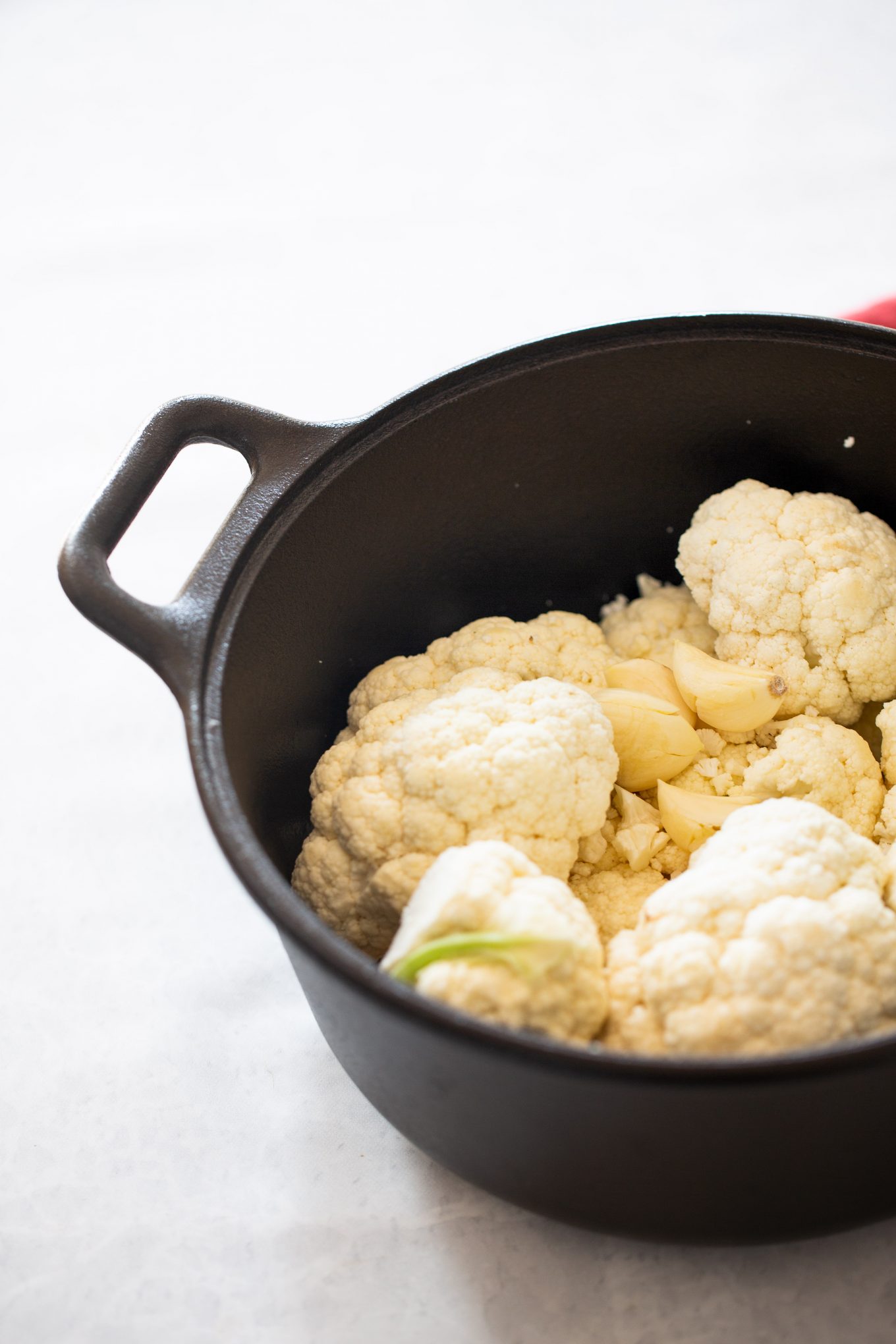 cauliflower florets in a pot with garlic cloves