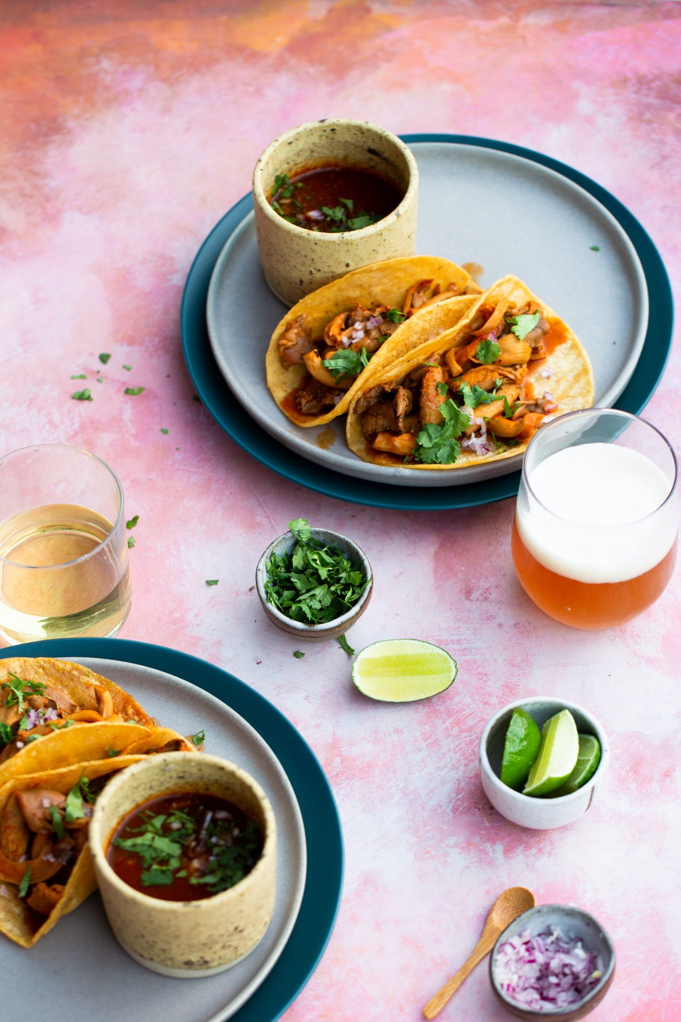 two plates with vegan birria tacos and the birra sauce on the side