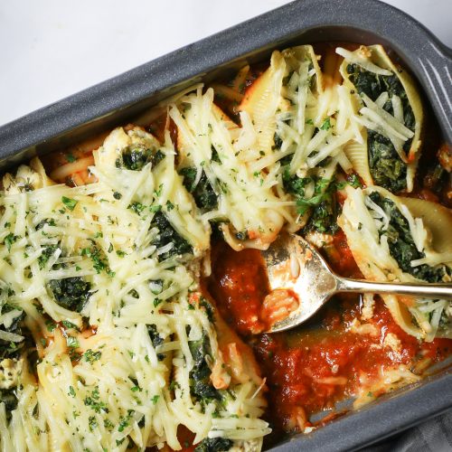 Vegan stuffed shells with spinach and cheese in a baking dish.