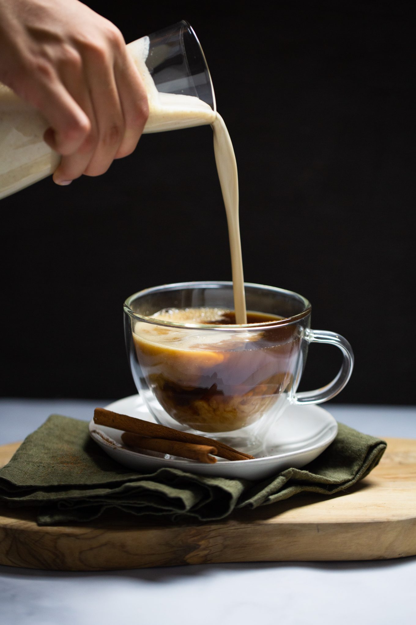 pouring vegan pumpkin creamer into a cup of coffee