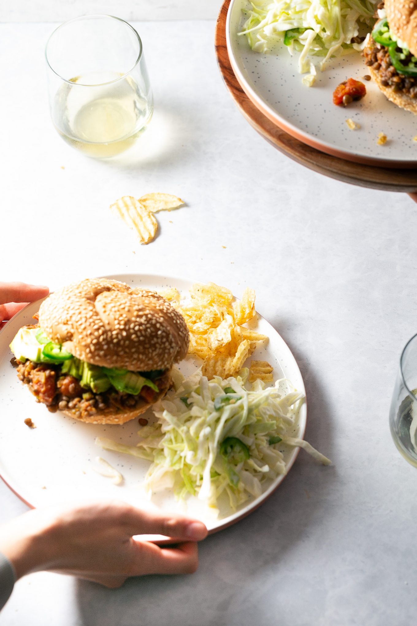 Lentil sloppy joes on a plate with chips and slaw.