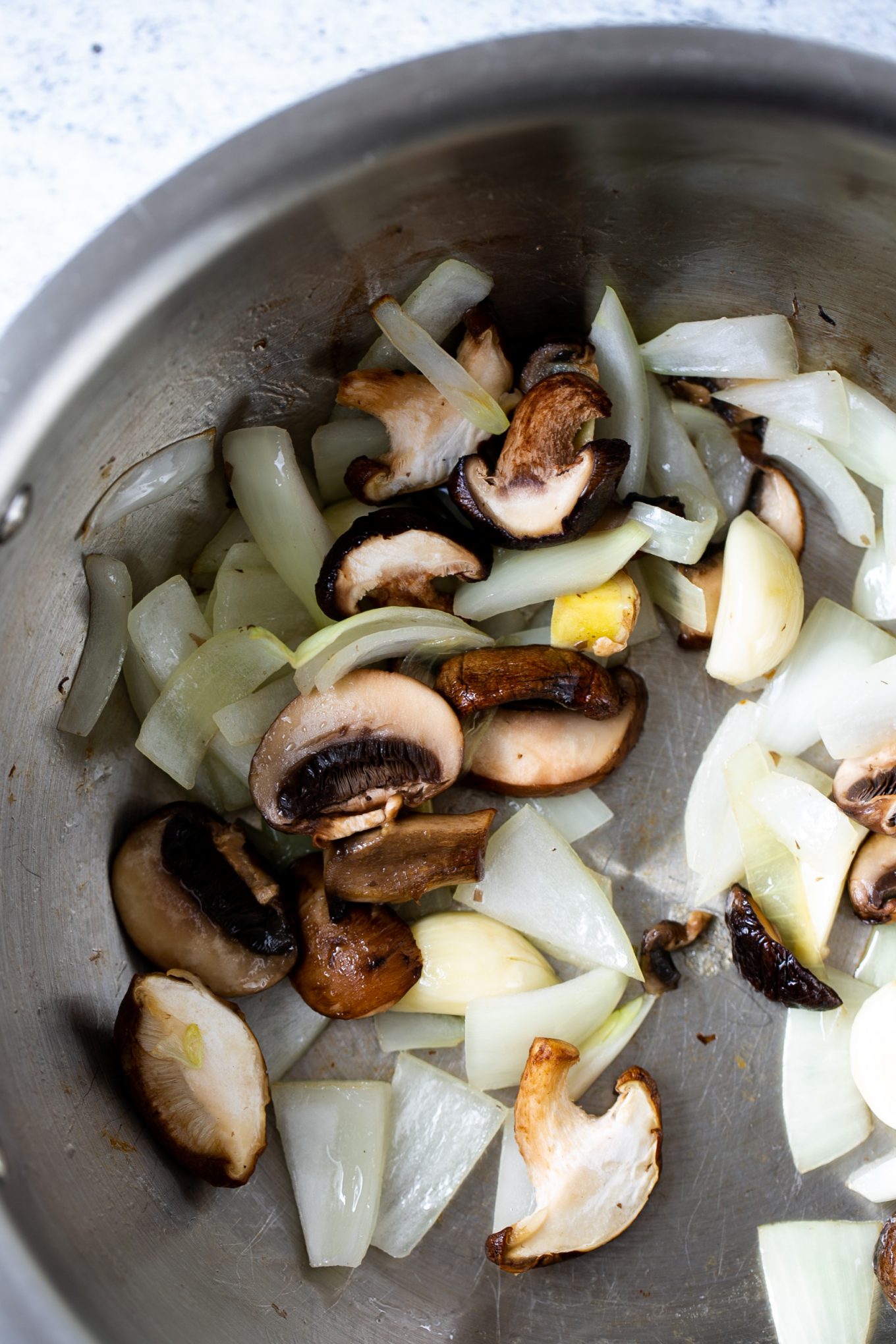 mushrooms, onion, garlic and ginger being sauteed in a pot