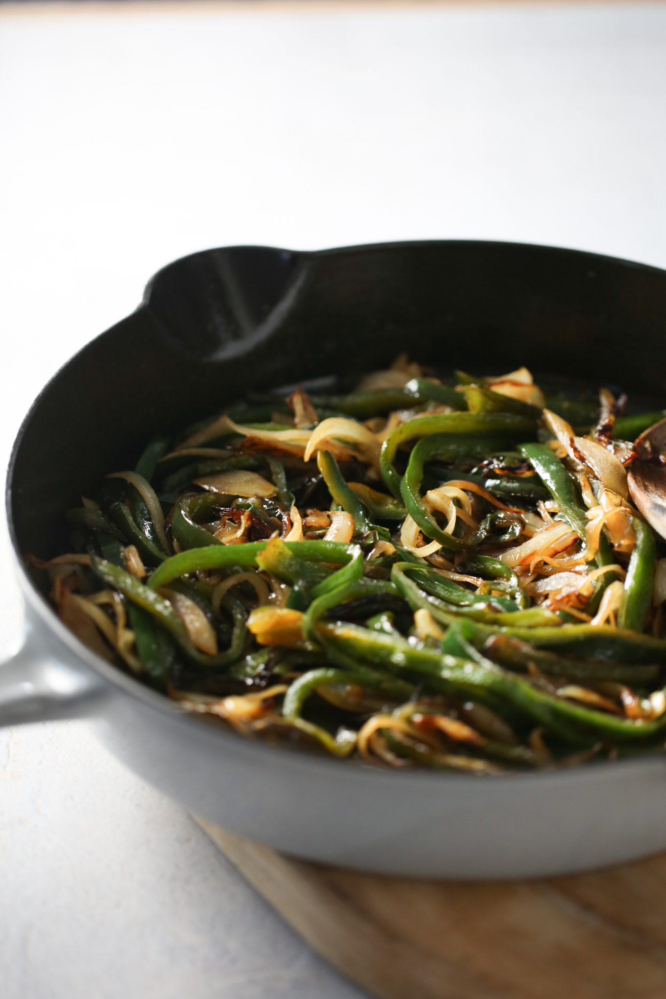 Rasted poblano peppers with onions in an iron cast skillet