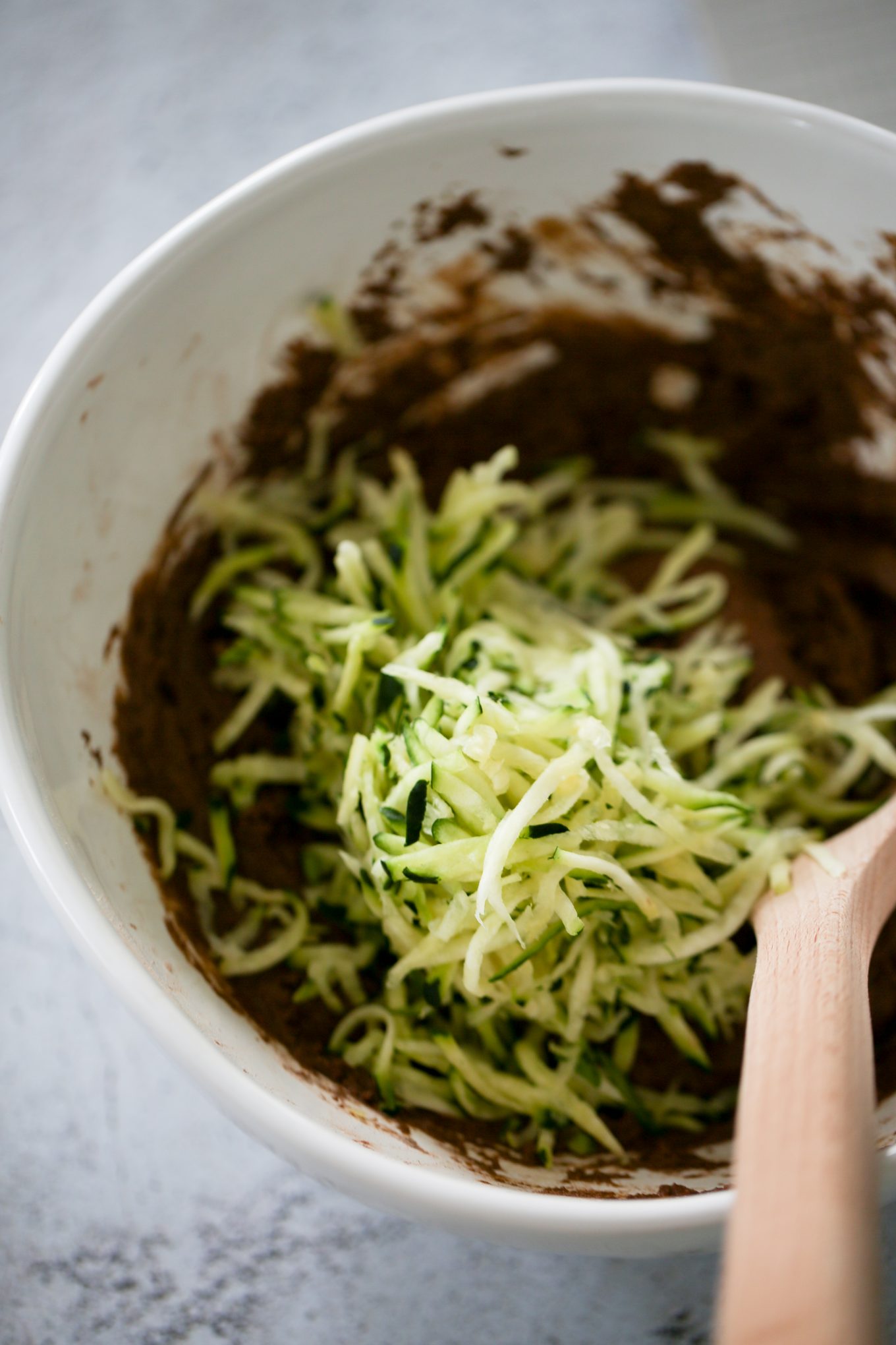 Agregando el zucchini rallado a la mezcla.