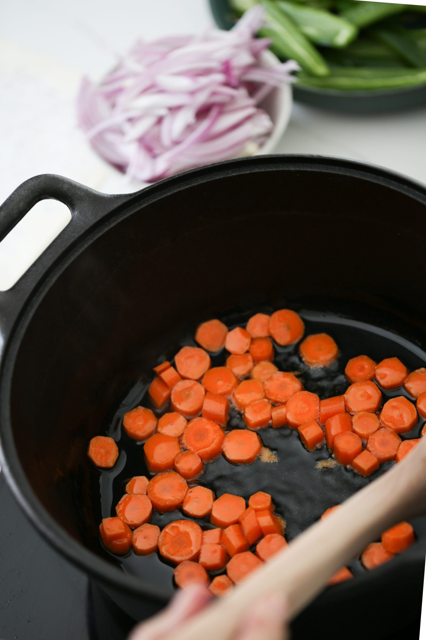 Sautéing onions in a large cast iron pan.