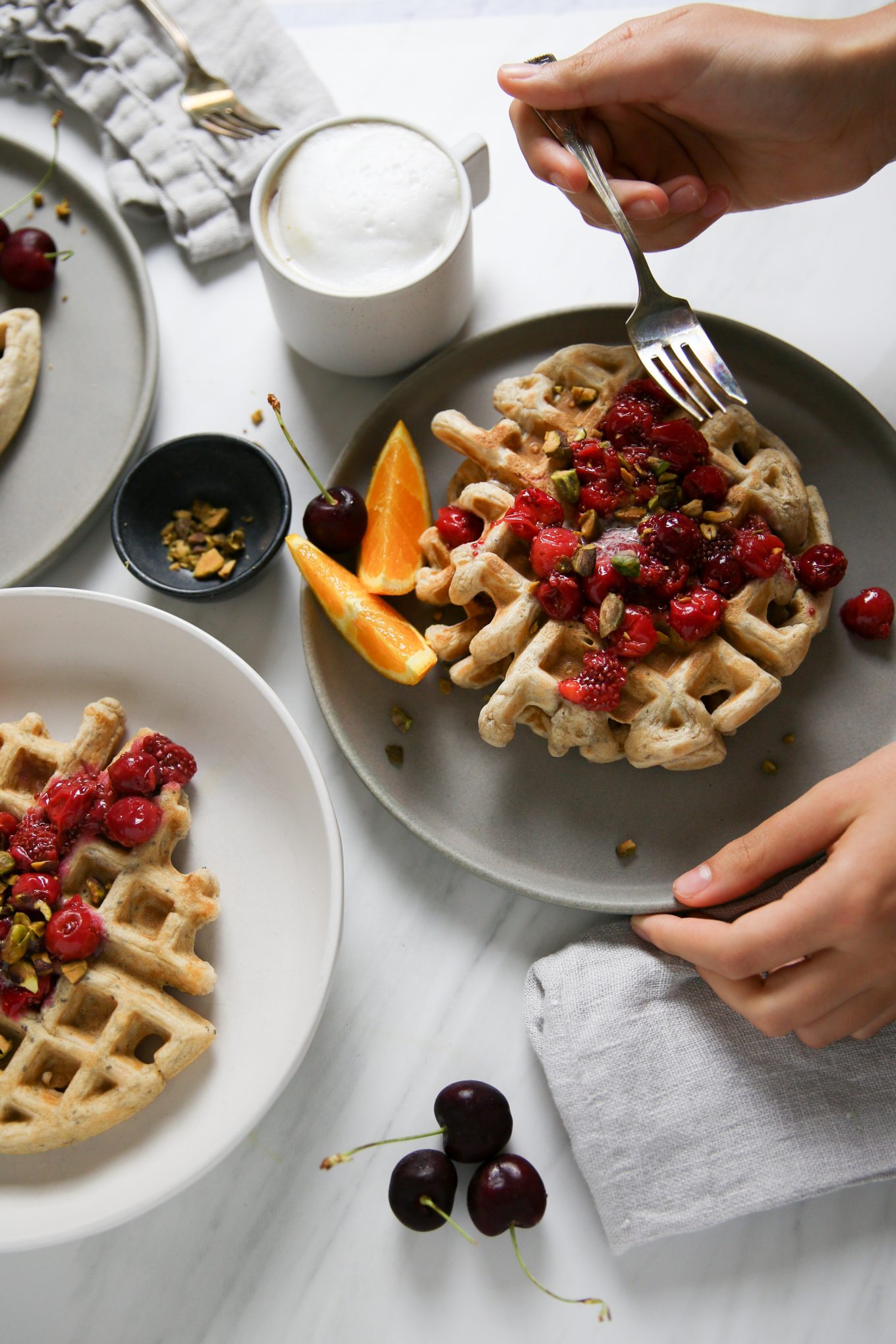 Homemade waffles with cherries and orange slices