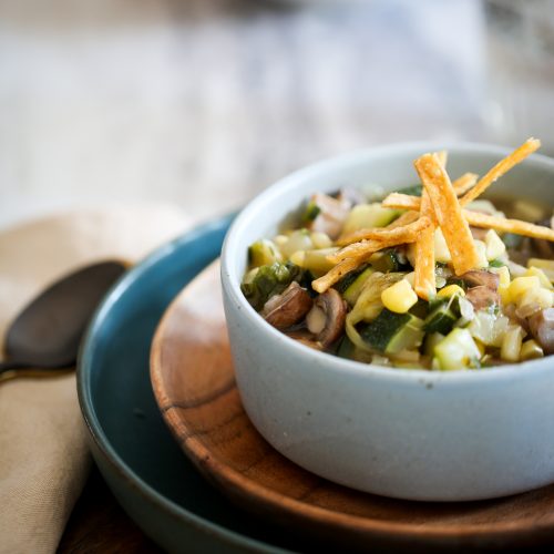 Mexican vegetable soup with tortilla chips on top.
