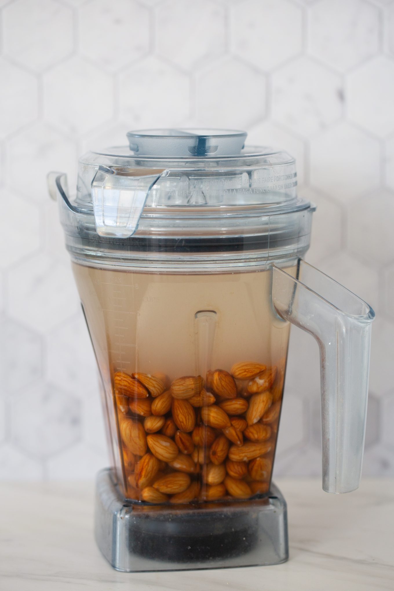 Blender jar filled with almonds and water