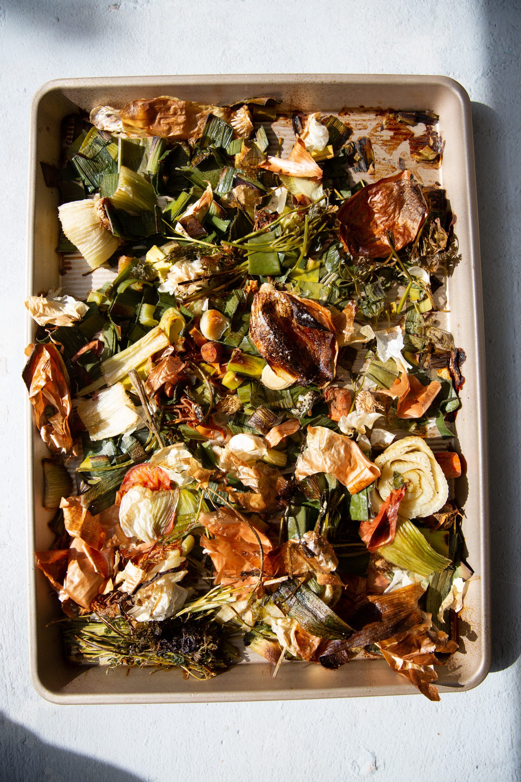 Roasted golden vegetable scraps on a baking sheet