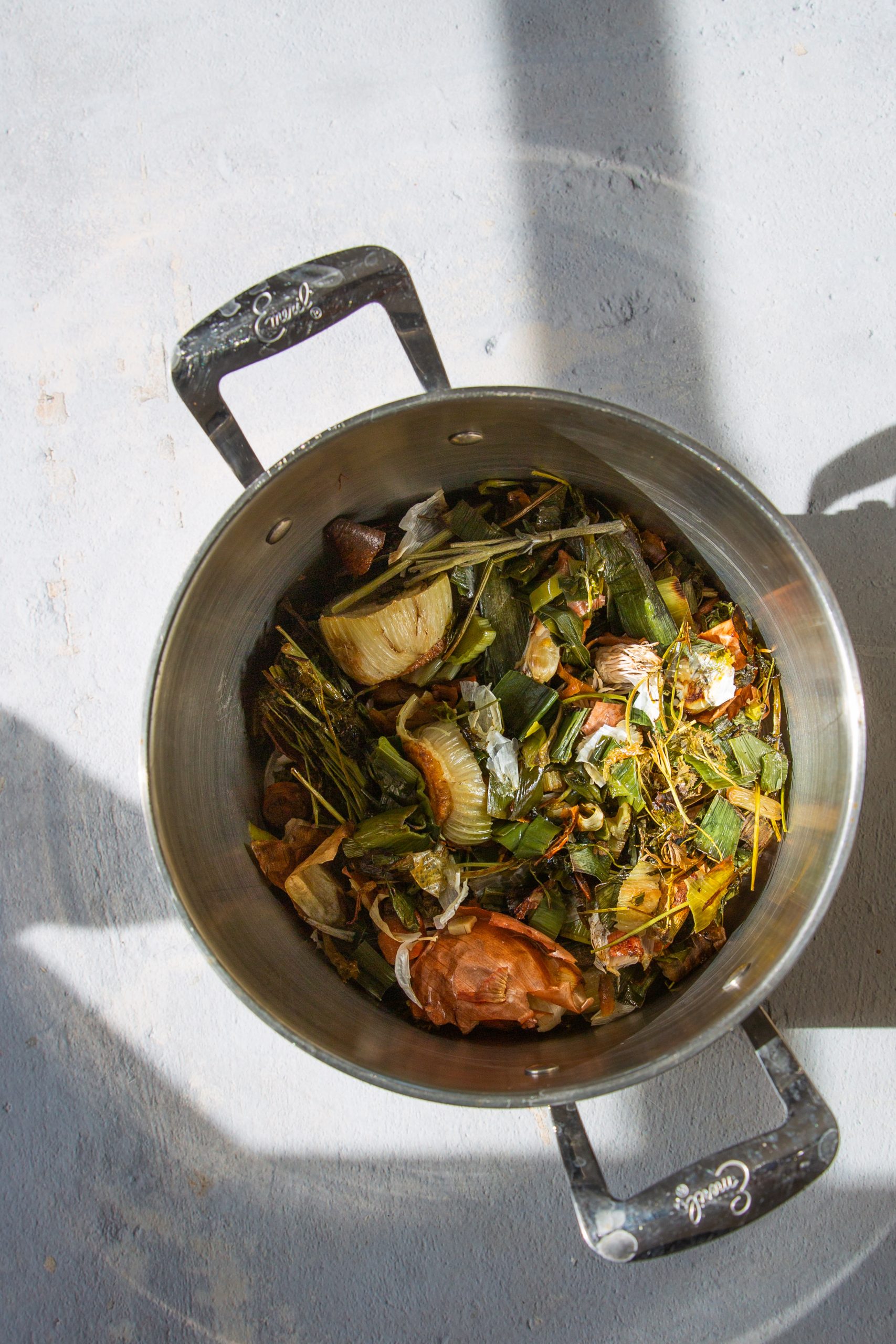 Roasted vegetable scraps simmering in a soup pot with water