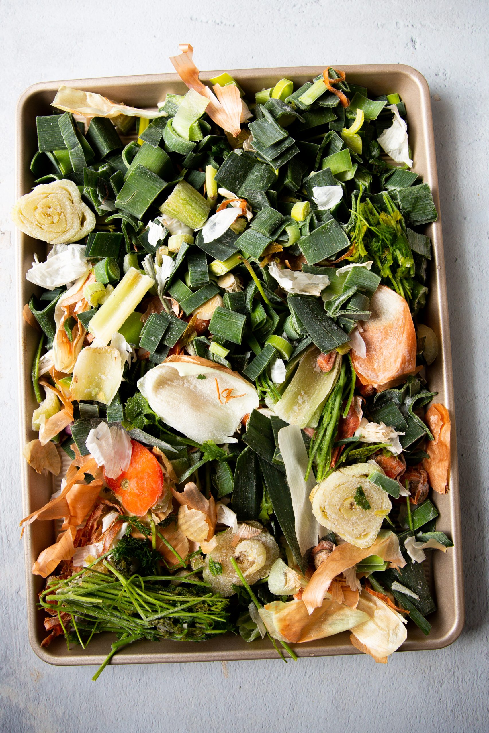 Raw vegetable scraps spread on a baking sheet