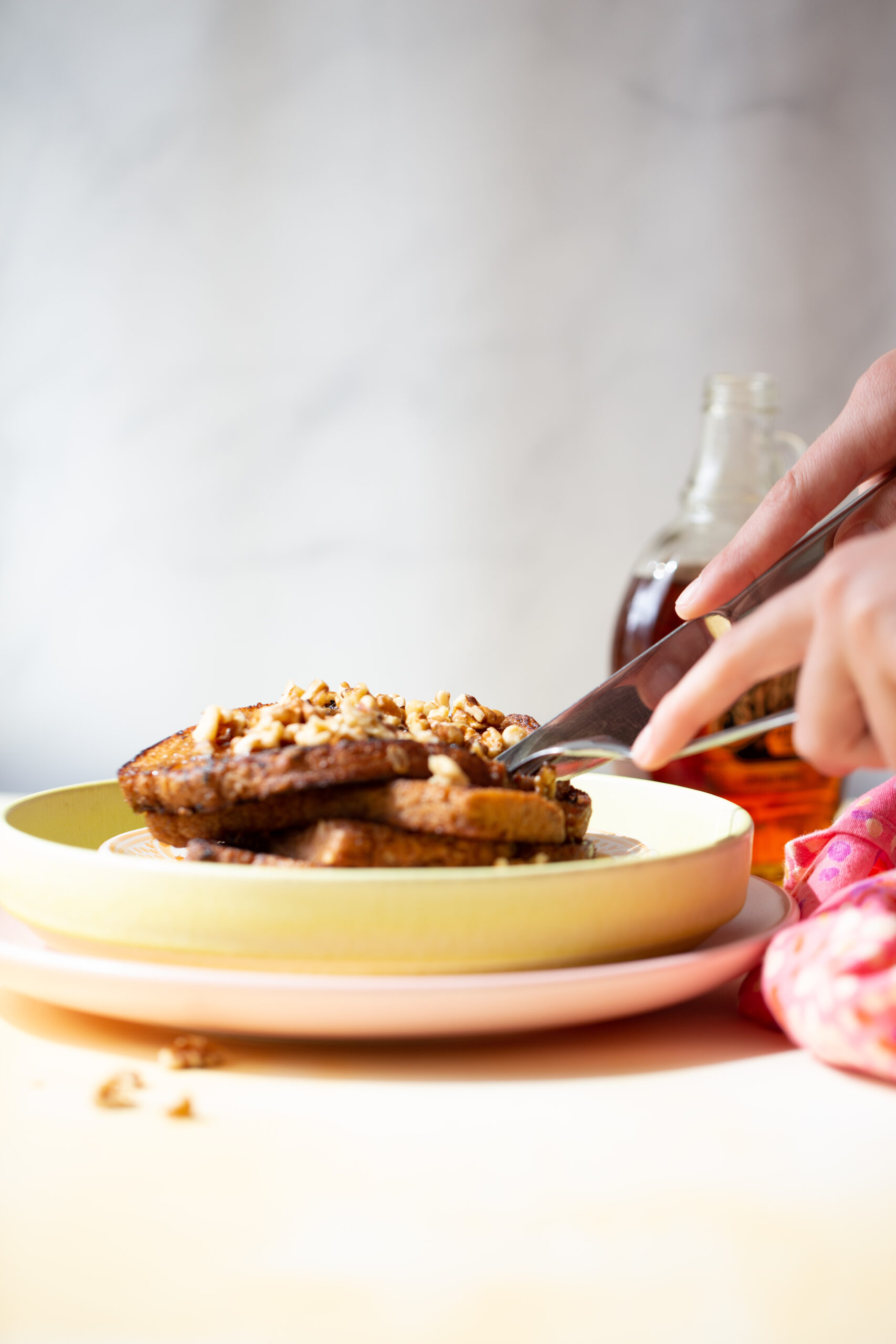 Stack of banana nut french toast with walnuts and maple syrup