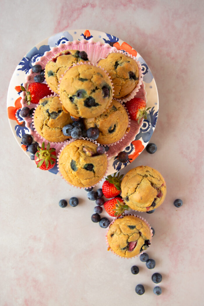 muffins veganos con moras en platos rosas y con moras y fresas a los lados