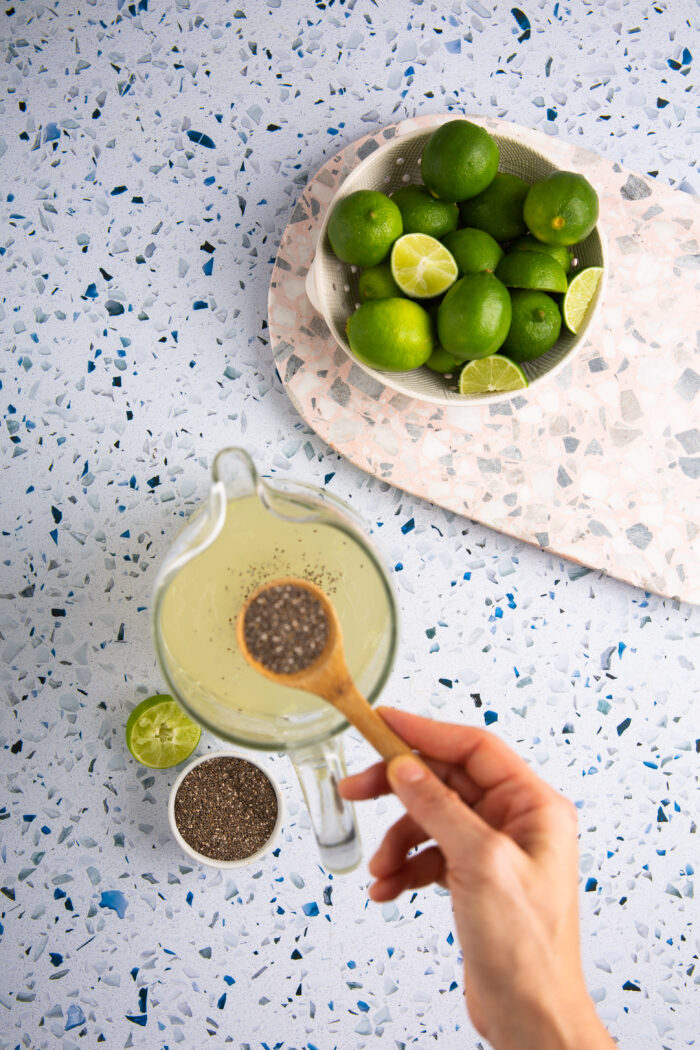 Adding chia seeds to a pitcher of limeade