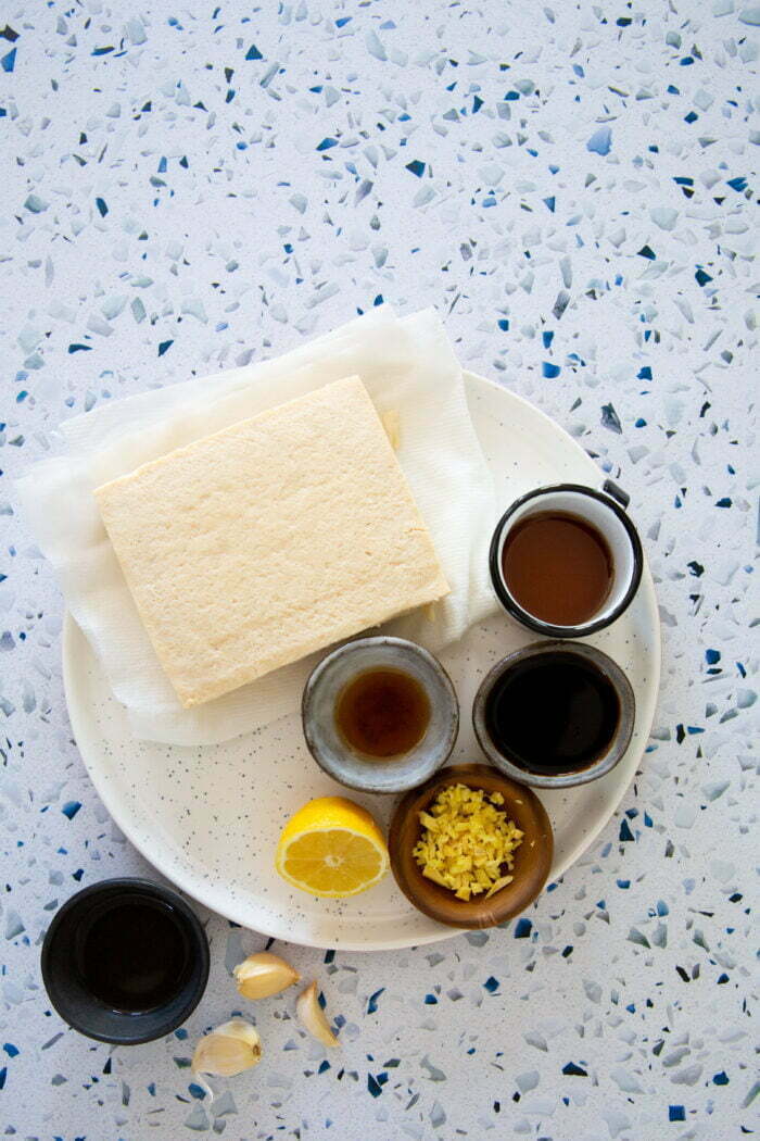 a block of tofu and some condiments to make a marinade