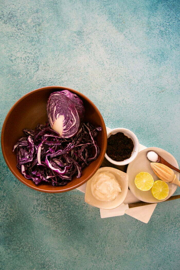 Red cabbage and mayo, chipótle peppers and lime all prepped in small bowls ready to make slaw.