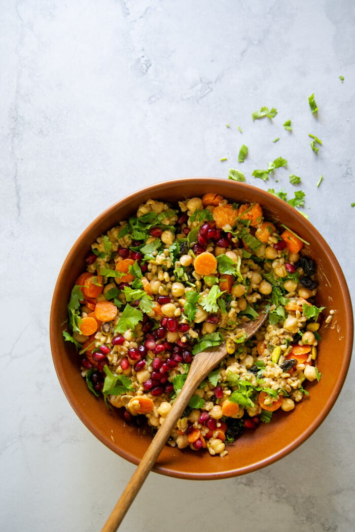 curried chickpea salad with farro in a brown serving dish