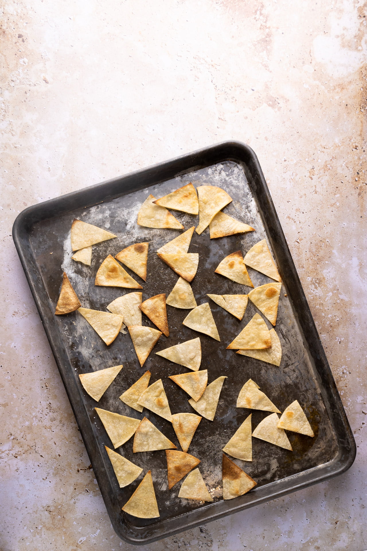 Air fryer tortilla chips on a baking sheet.